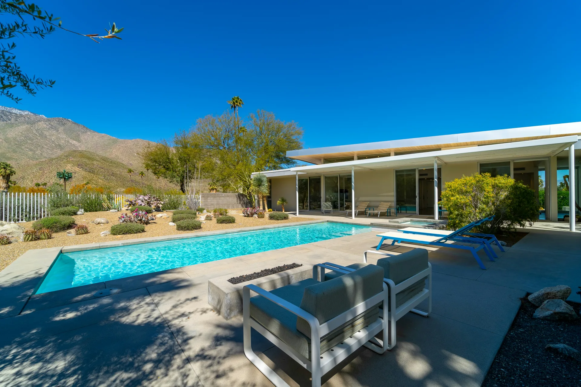 Patio sun loungers next to a clean blue pool